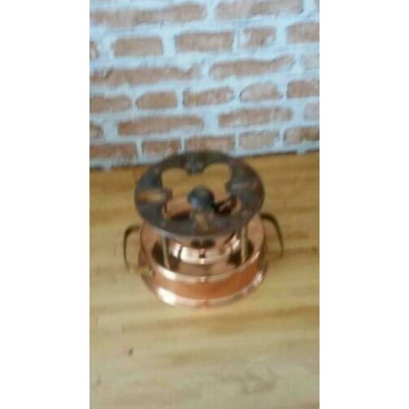 Koperen rechaud op gas.