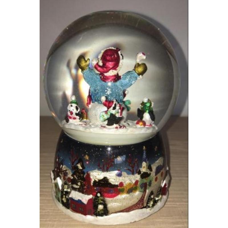 Draaiende sneeuwpop in glazen bol met kerst muziek
