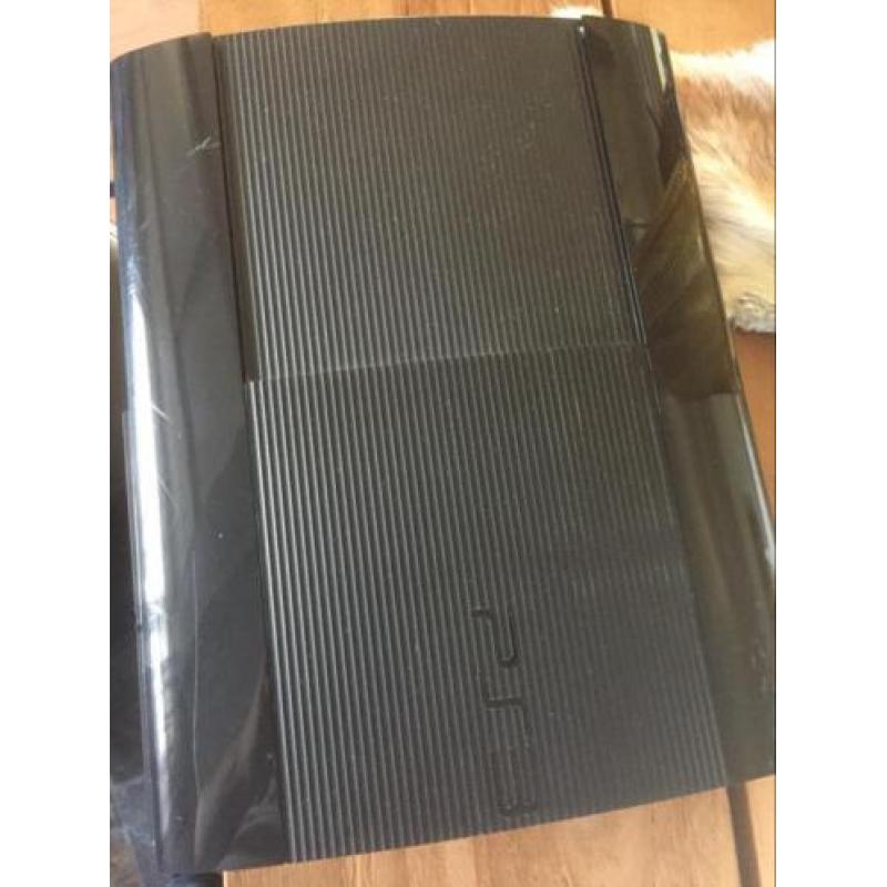 Ps3 zwart 1tb superslim met een controller en games.
